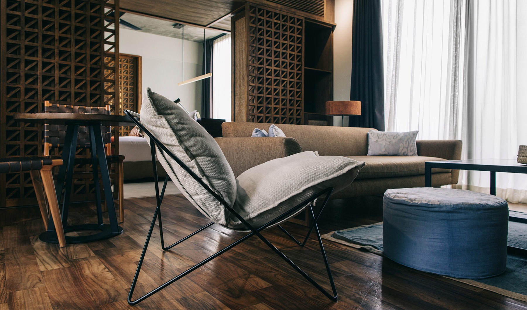 Modern living room with rich hardwood floors and oversized windows