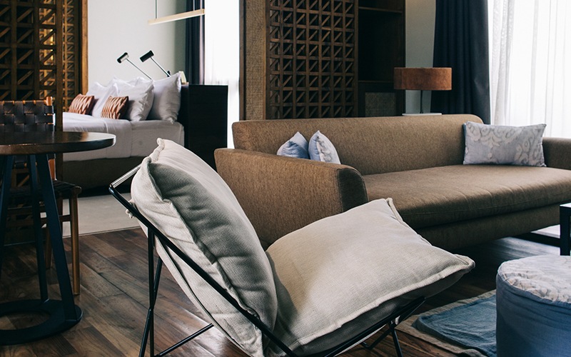 Living room with modern and moody furniture next to oversized windows