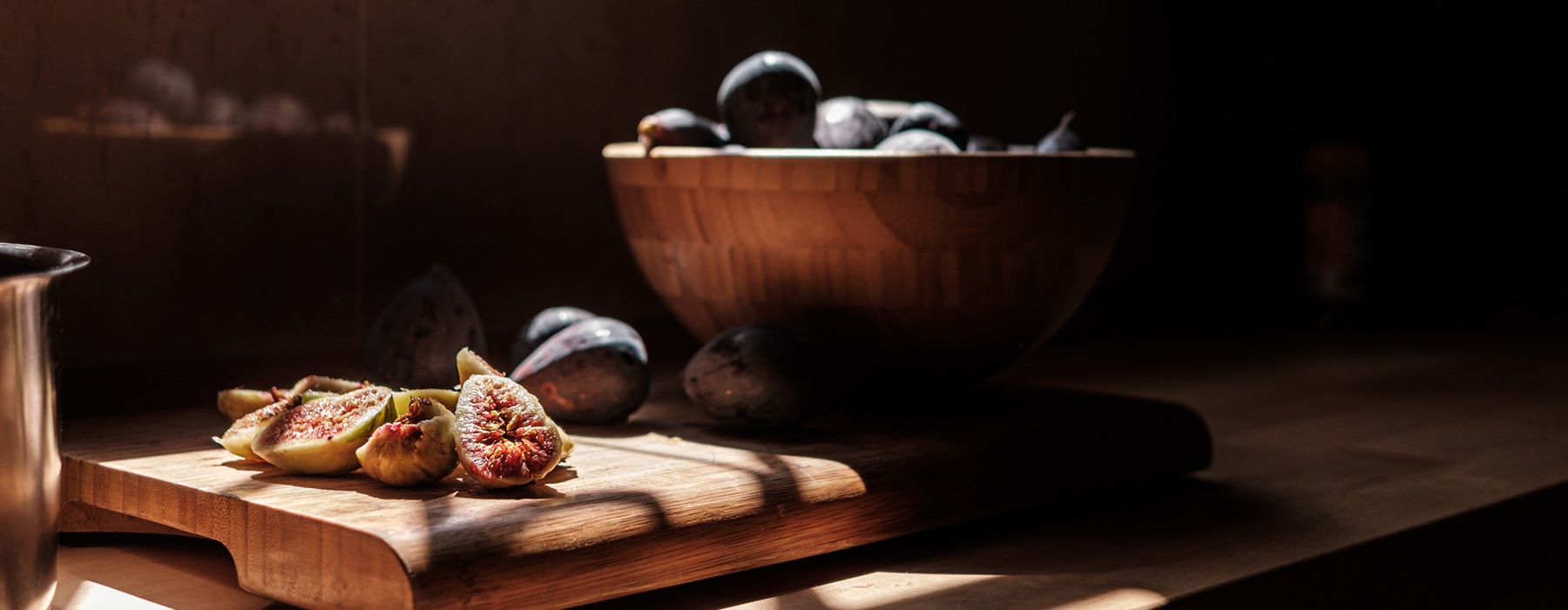 Close up of figs on a naturally yet dimly lit kitchen counter